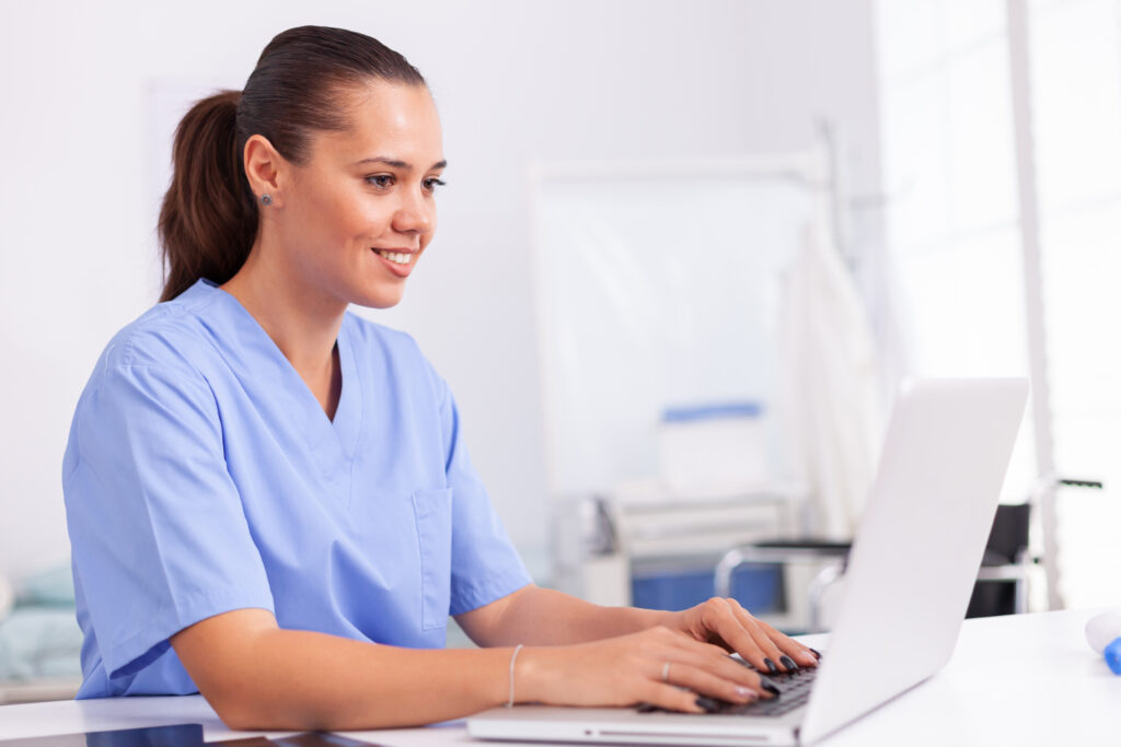 medical nurse uniform using laptop sitting desk hospital office health care physician using computer modern clinic looking monitor medicine profession scrubs.jpg